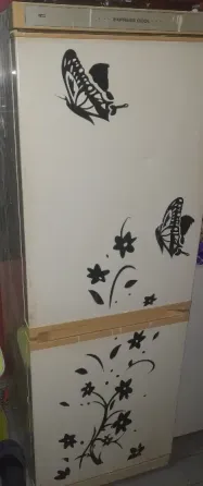 Холодильник с наклейками в виде бабочек и цветов