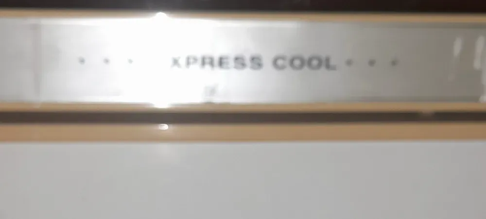 Ближайшее изображение верхней панели холодильника с логотипом 