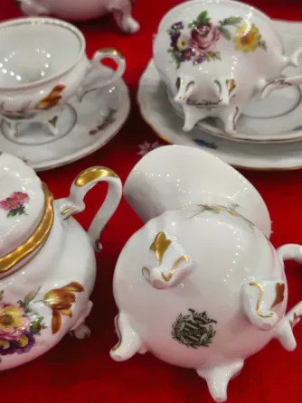 Сервиз с цветочными узорами, чайник, сахарница, молочник и чашки на полке