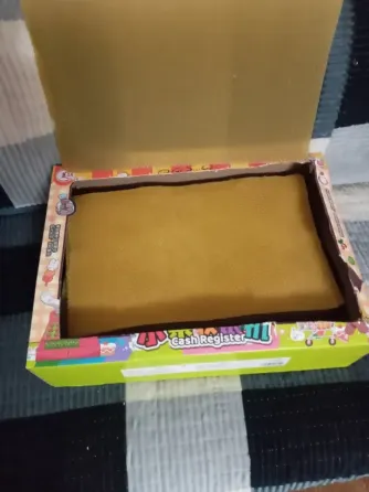 Коробка с желтыми детскими аксессуарами, открытая и заполненная накладками