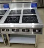 Индукциялық конфоркалармен жабдықталған электр плитасы, металл корпус, тағам дайындауға арналған төрт панель, реттелетін басқару тұтқалары.