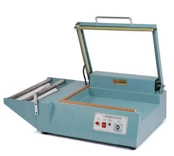 Промышленная термоусадочная упаковочная машина в голубом корпусе с управлением и открывающимся верхом