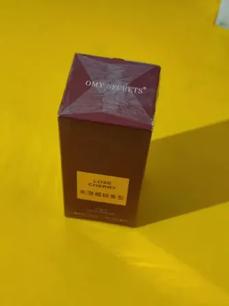 упаковка парфюма Lose Cherry на фоне гирлянд