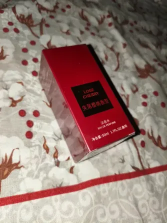 упаковка парфюма Lose Cherry на фоне гирлянд