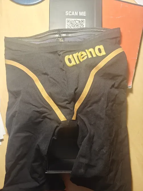 Купальные шорты марки Arena черного цвета с золотыми полосами и логотипом