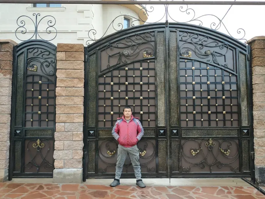 Ворот с человеком рядом в роскошном дворе