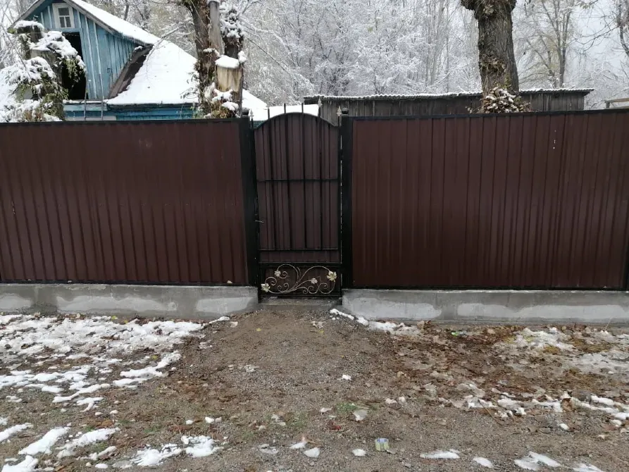 Забор с калиткой в зимнем пейзаже