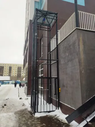 Строительная конструкция с вертикальным подъемником рядом со зданием