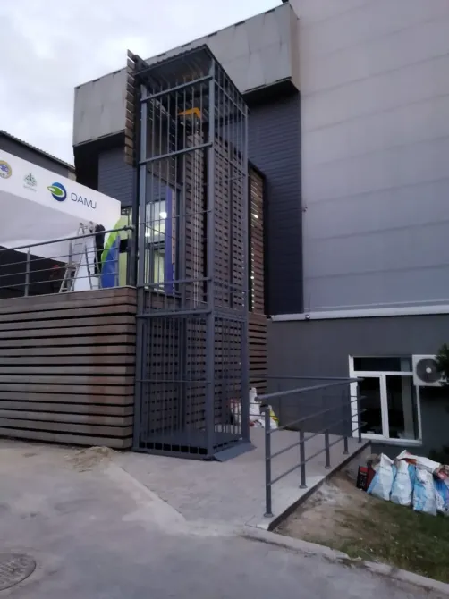 Строительная конструкция с вертикальным подъемником рядом со зданием