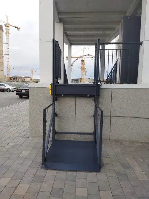 Подъемная платформа с воротами у входа в здание с облицовкой из плитки