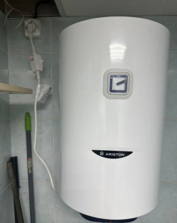 Мужчина с молотком и инструментами стоит у лестницы, готов помочь с ремонтом