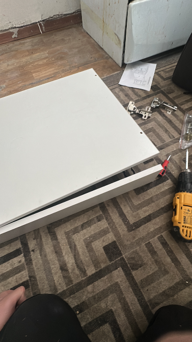 Часть белого шкафа с инструментами на полу