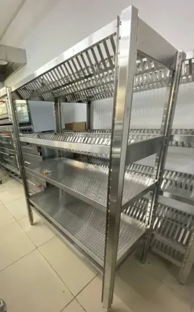 Металлическая стеллажная система с перфорацией для хранения продуктов в коммерческой кухне. С несколькими полками для оптимального использования прост