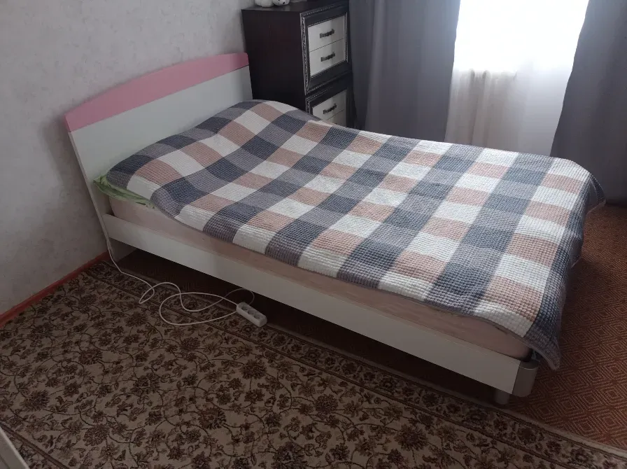 Кровать с пледом в клетку и светлым покрытием