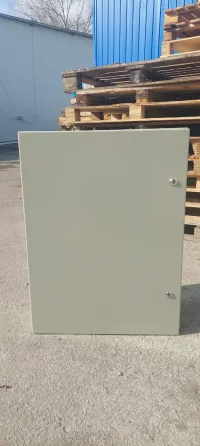 Серая металлическая панель в вертикальном положении на фоне деревянных поддонов