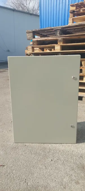 Серая металлическая панель в вертикальном положении на фоне деревянных поддонов