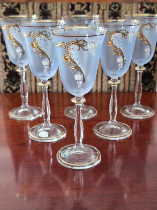 Шестигранные бокалы с золотыми узорами на фоне текстиля