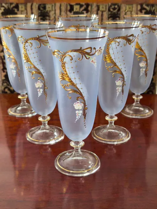 Стеклянные бокалы с золотым декором на деревянной поверхности