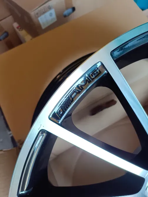 Крупный план диска колес с логотипом AMG, черный с хромированными элементами, в коробке