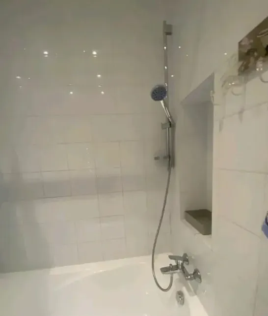 Ванная комната с унитазом и раковиной на фоне светлой плитки