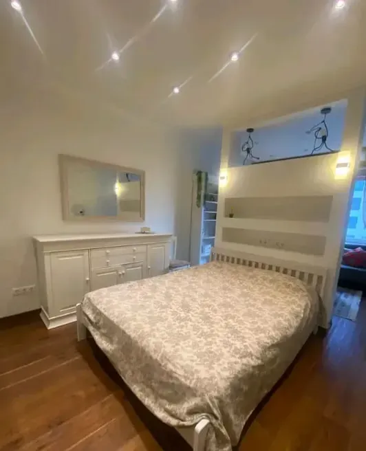 Спальня с кроватью и деревянным полом