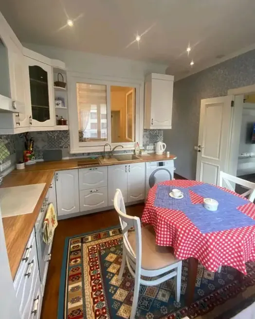 Кухня с окном, столом, красной скатертью и обеденной зоной