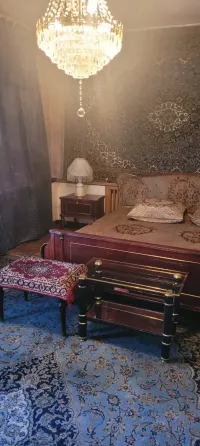 Комната с кроватью, люстрой и восточными коврами