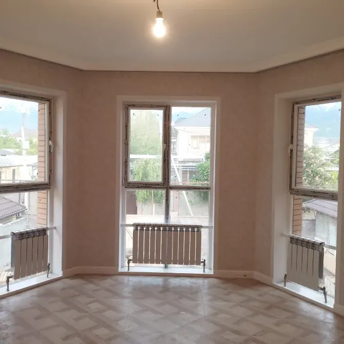 Интерьер комнаты с большими окнами и радиаторами