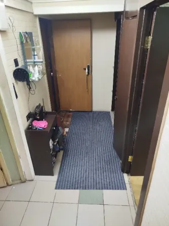 Кухня с белыми кухонными шкафами, плитой и стиральной машиной, окнами с занавесками в геометрический узор