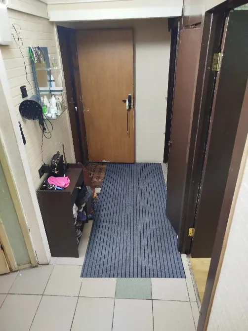 Коридор с дверью, ковриком и полкой для обуви, стены в нейтральных тонах