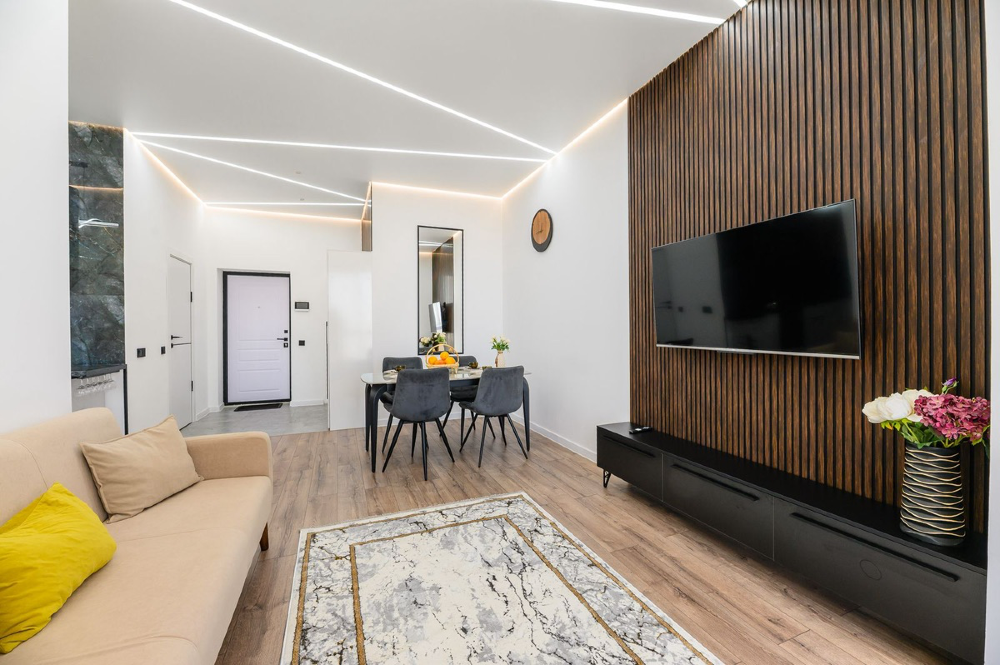 Современный гостиный уголок с телевизором и деревянной стеной