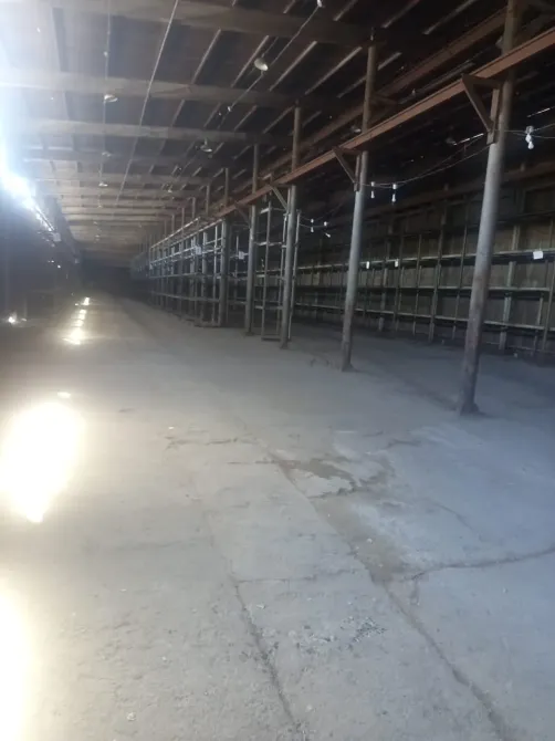 Пустое пространство внутри склада с металлическими стеллажами и освещением