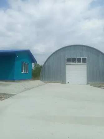 Домик и ангар на парковке в ясный день