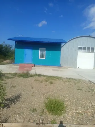 Домик и ангар на парковке в ясный день