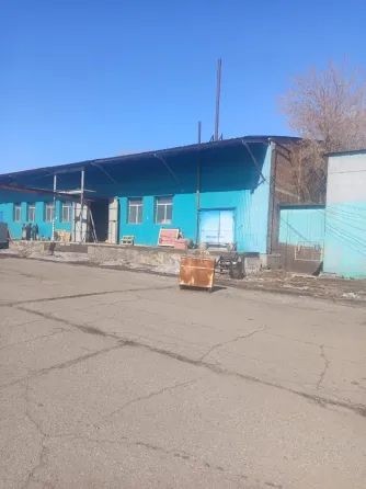 Здание с зеленой окраской на фоне зимнего пейзажа