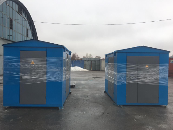 Үлкен көк электр щиті сұр есіктермен бұлтты аспан аясында