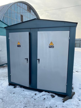 Үлкен көк электр щиті сұр есіктермен бұлтты аспан аясында