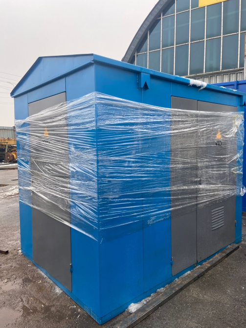 Синий электрический щит, завернутый в пленку на фоне серого неба