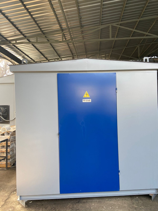 Электрическая подстанция с синей дверью под серым навесом