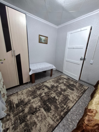 Помещение с двумя кроватями, ковром и окнами с занавесками