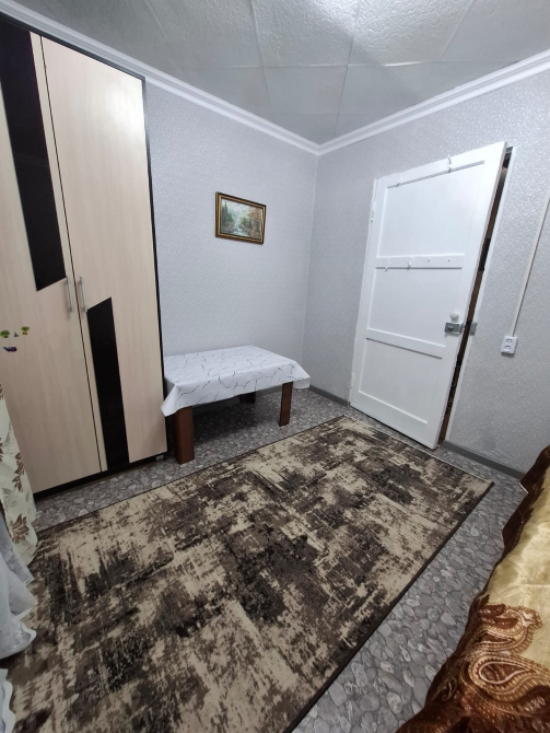 Интерьер комнаты с шкафом, столом и входной дверью