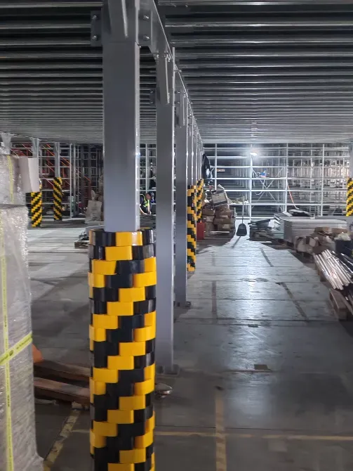 Внутренний вид склада с защитными колоннами и металлическими стеллажами