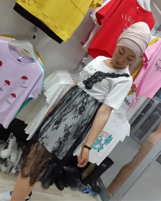 Девушка в платье с кружевом на фоне других футболок