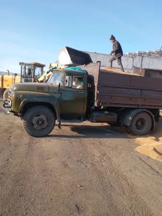 Погрузчик Liugong загружает снег в кузов грузовика на снежной площадке
