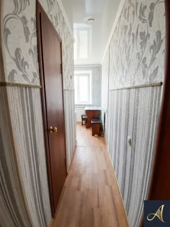 Современный светлый интерьер спальни с диваном и телевизором, длинными занавесками