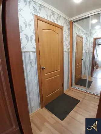 Современный светлый интерьер спальни с диваном и телевизором, длинными занавесками