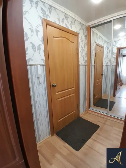 Коридор с зеркальной дверью шкафа и уютным оформлением стен