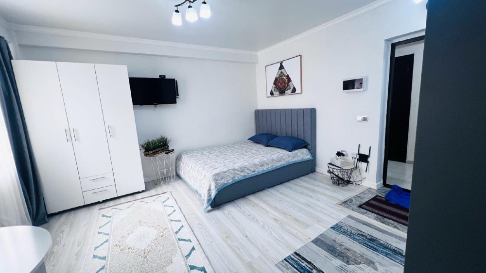 Уютная спальня с шкафом, телевизором и комфортной атмосферой