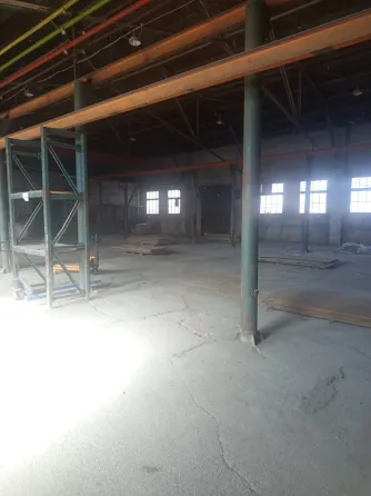 Көгілдір қабырға мен екі терезесі бар ғимарат ашық аспан фонында