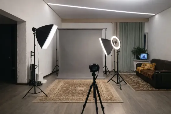 Студийная фотосессия с камерой на штативе, осветительными оборудованием и нейтральным фоном